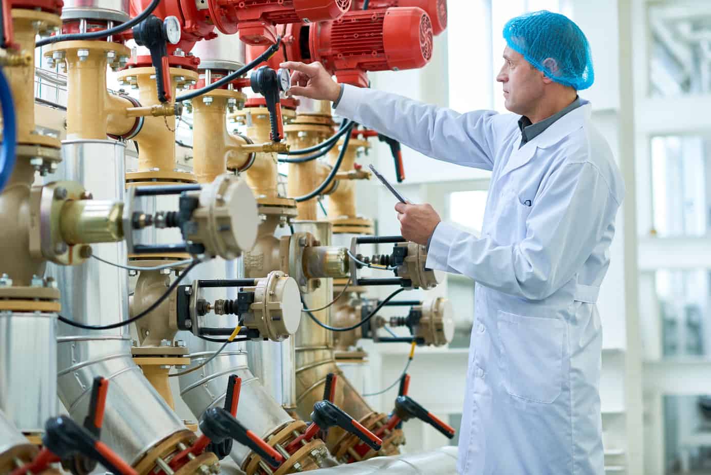 Worker Checking Pipes and valves in Factory